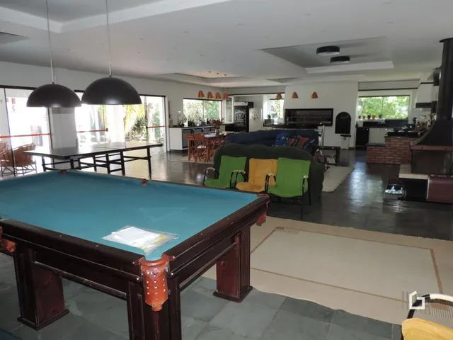 Imagem de uma sala com uma mesa grande no interior de uma propriedade.