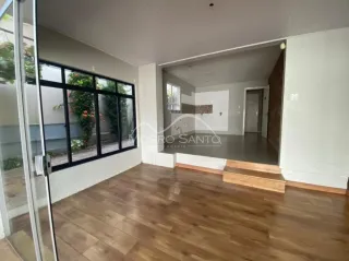 Sala de estar com piso de madeira e porta de vidro que dá acesso ao exterior.