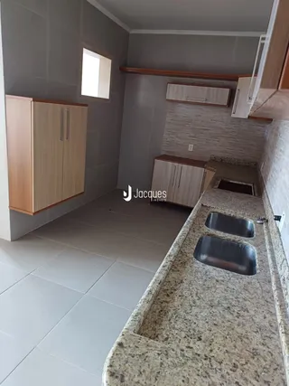 Interior de uma área com armários e bancada em um imóvel.