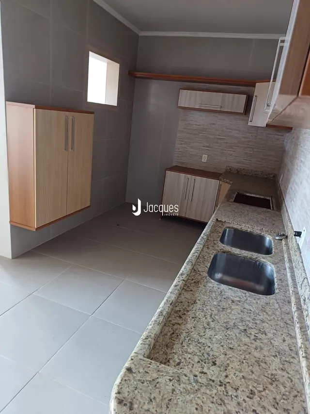 Interior de uma área com armários e bancada em um imóvel.