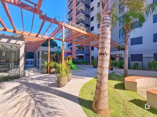 Vista externa de um pátio com pérgola e jardim em uma residência.