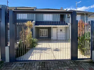 Fachada frontal de uma residência com portão de metal em Lajeado, Brasil.