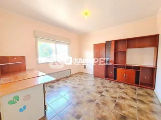 Foto interna de uma sala com piso de cerâmica e armários em madeira.