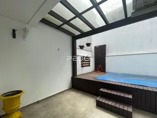 Espaço interno com teto de estrutura metálica e piso de cerâmica.