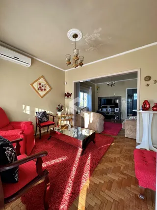 Sala de estar com piso de madeira e decoração em tons quentes.