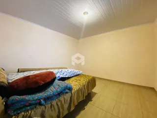 Quarto com cama e piso de cerâmica claro.