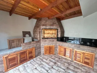 Ambiente interno com parede de pedra e piso de cerâmica no imóvel.