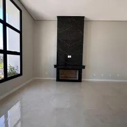Sala de estar com lareira de pedra escura em ambiente claro.