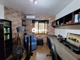 Sala de estar com piso de madeira e janela mostrando a vista externa.
