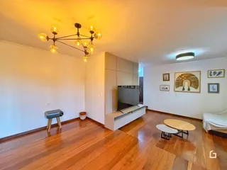 Sala de estar com piso de madeira e televisão.