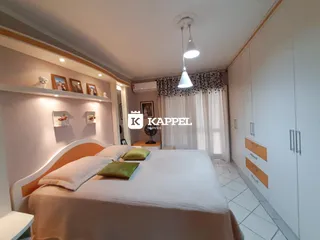 Quarto com cama grande e decoração clara em ambiente bem iluminado.