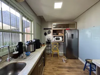 Foto interna de uma cozinha com janelas grandes e piso de madeira.