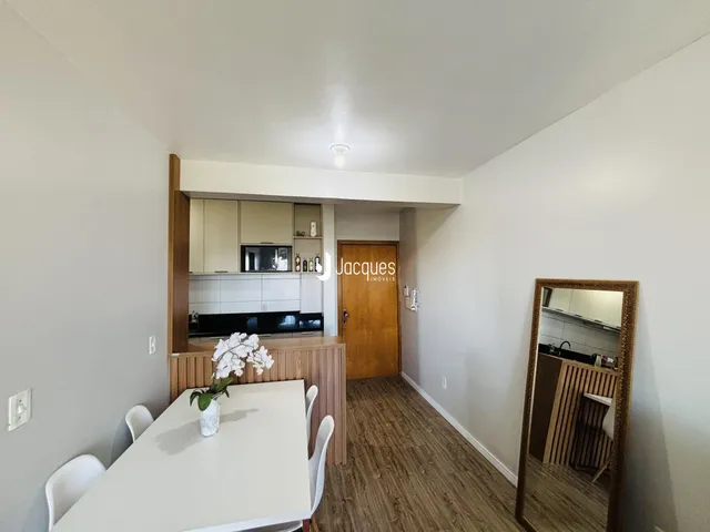 Vista interna de uma sala com mesa de jantar e espelho em um imóvel em Lajeado.