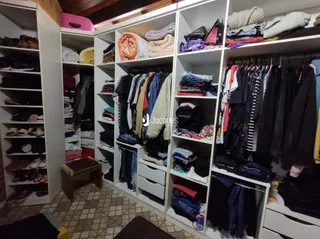 Exposição de roupas em prateleiras brancas de um imóvel.