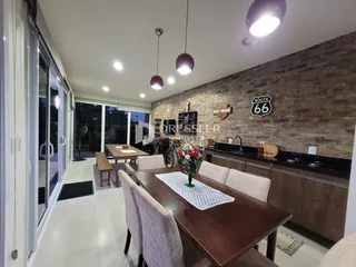 Vista de uma sala de jantar com mesa de madeira e portas de vidro.