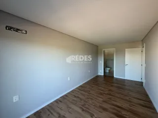 Imagem de uma sala de estar com piso de madeira clara.