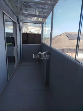 Corredor interno com grandes janelas de vidro em uma propriedade.