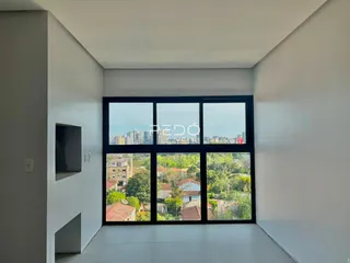 Sala de estar com grande janela de vidro mostrando a paisagem da cidade.
