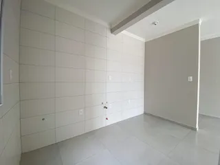 Hall de entrada com paredes brancas e piso de porcelanato claro.