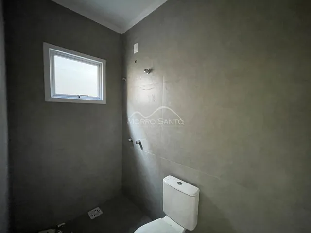 Foto de um banheiro com paredes cinzas e uma janela.