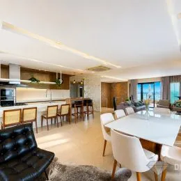 Foto interna de uma sala de estar com sofá e iluminação clara.