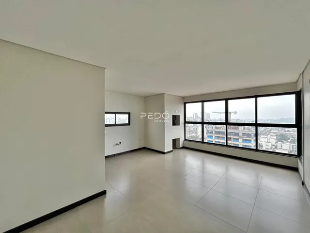 Ambiente interno de uma sala ampla com vista para a cidade.