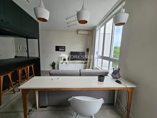 Sala de estar com grandes janelas e decoração moderna.
