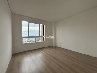Sala de estar com piso de madeira e grande janela.