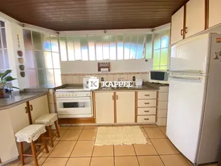 Cozinha com armários brancos e piso de cerâmica.