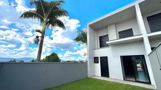 Fachada de uma casa moderna em Lajeado, Brasil com gramado e palmeira.