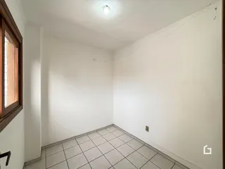 Foto de um cômodo interno com paredes brancas e piso de cerâmica.