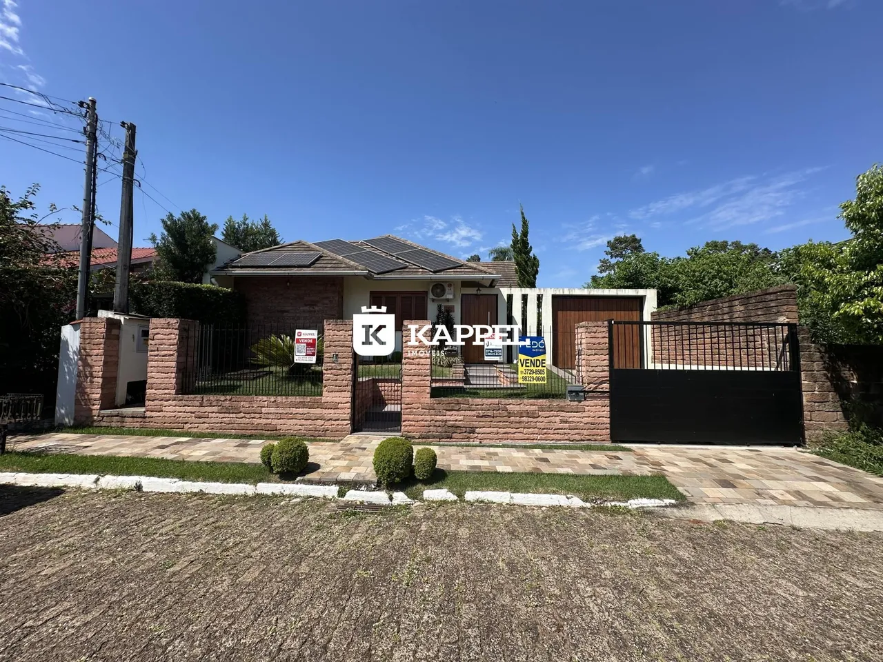 Fachada de uma residência em Lajeado, Brasil, com muro e portão de ferro.