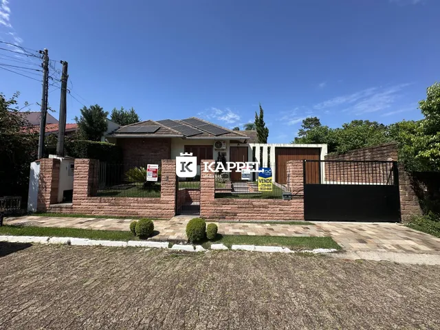 Fachada de uma residência em Lajeado, Brasil, com muro e portão de ferro.