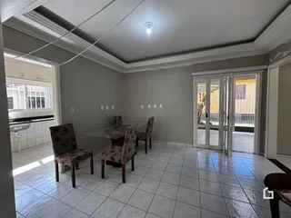Sala de jantar com piso de cerâmica e molduras no teto.