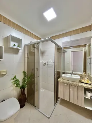 Banheiro com box de vidro e bancada em Lajeado, Brasil.