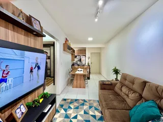 Sala de estar com sofá e televisão em um imóvel no Brasil.