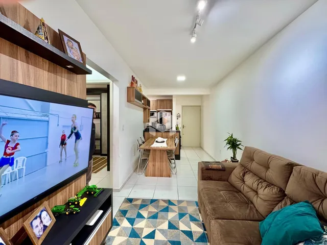 Sala de estar com sofá e televisão em um imóvel no Brasil.
