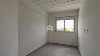 Ambiente interno de uma sala ou corredor com paredes brancas e teto de painéis.