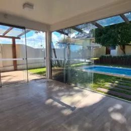 Sala de estar com acesso a uma área externa com piscina e jardim.