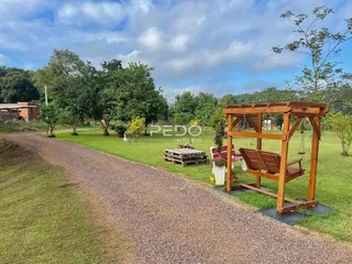 Vista externa de um terreno com gramado e uma estrada de terra.