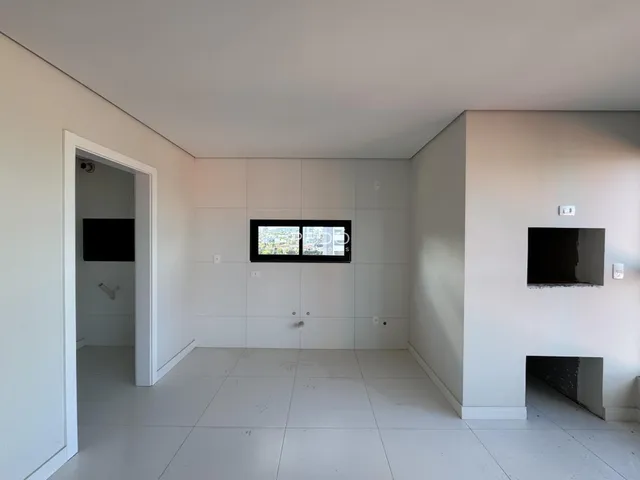 Ambiente interno de uma sala com paredes brancas e piso claro.