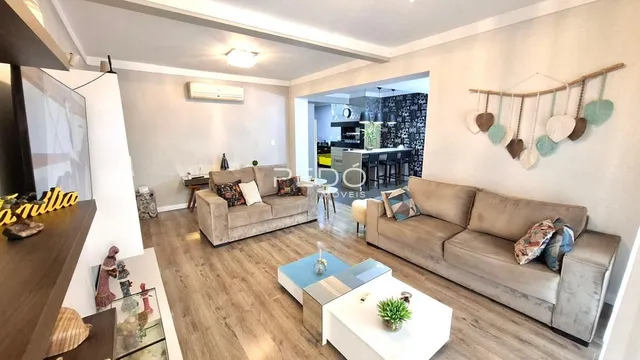 Sala de estar moderna com dois sofás e piso de madeira clara.