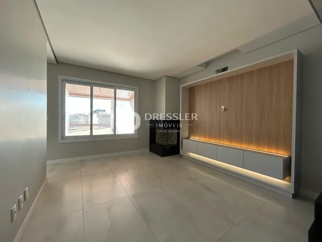 Sala de estar com piso claro e parede de destaque de madeira.