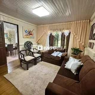 Sala de estar com sofá e cortinas claras.