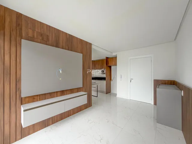 Sala de estar com painel de madeira e piso de mármore branco.