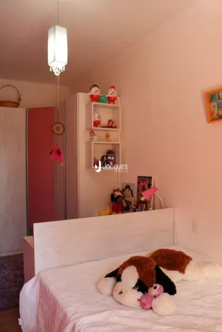 Quarto com cama grande e paredes claras.