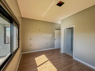 Sala de estar com piso de madeira e paredes claras.