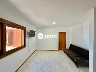 Sala de estar com piso de cerâmica e sofá escuro.