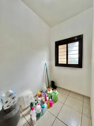 Interior de um cômodo com paredes brancas e piso de cerâmica.