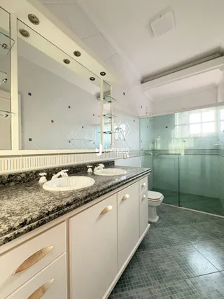 Foto de um banheiro com bancada de granito e piso de cerâmica.